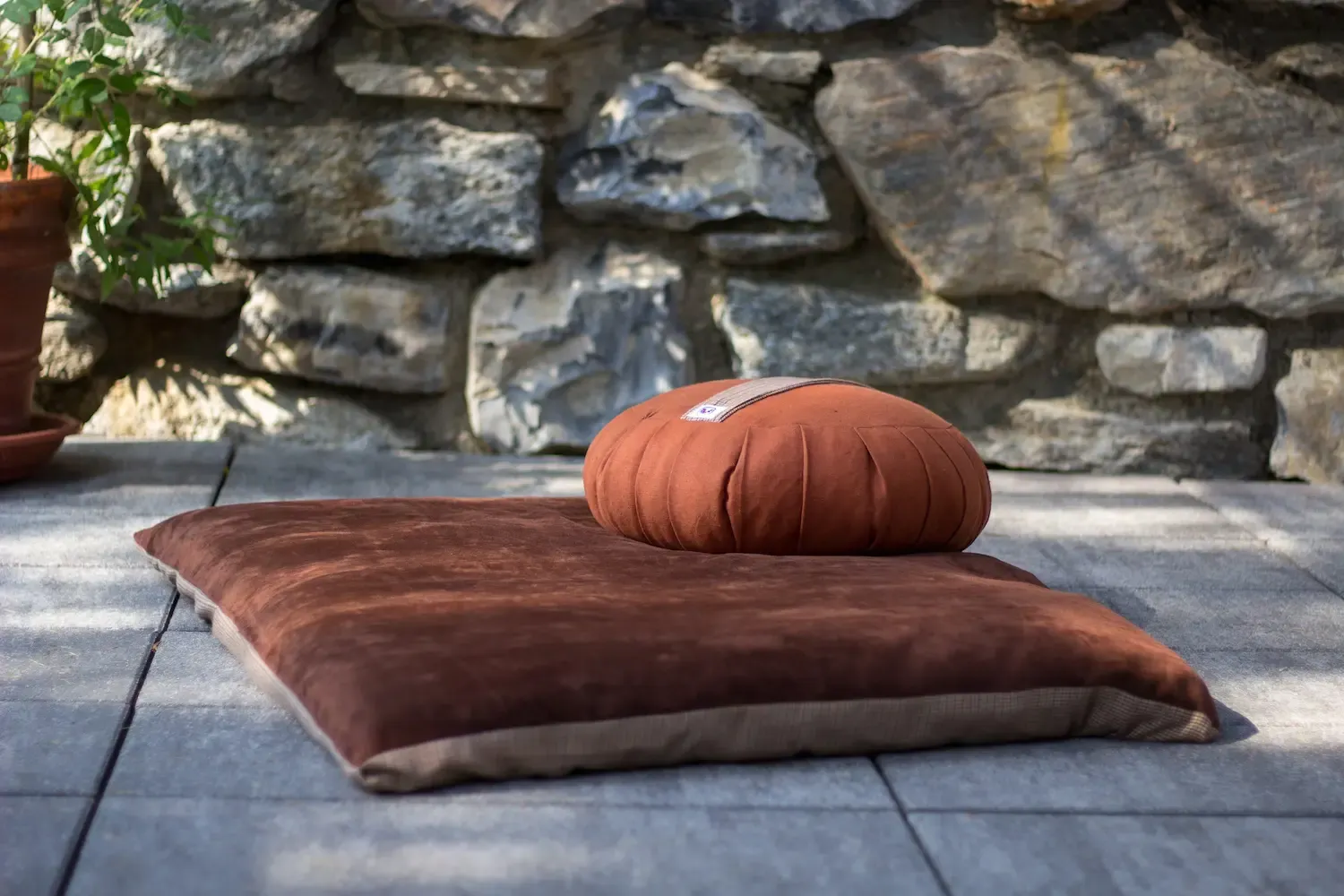 Meditation cushion and bolster set on a stone patio