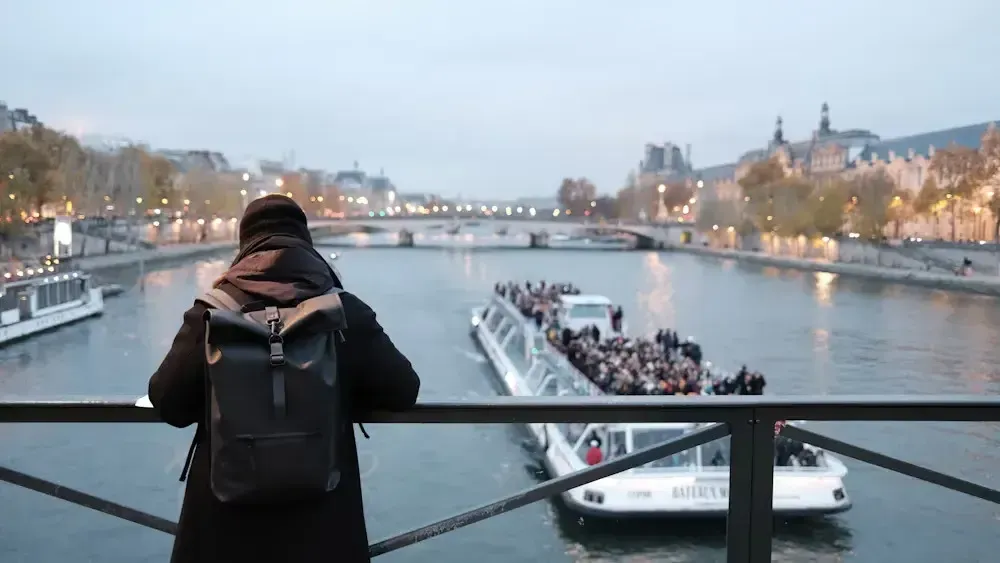 a person standing on a bridge looking at a large crowd of people